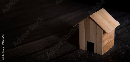 wooden home on dark wooden background, home loan concept.