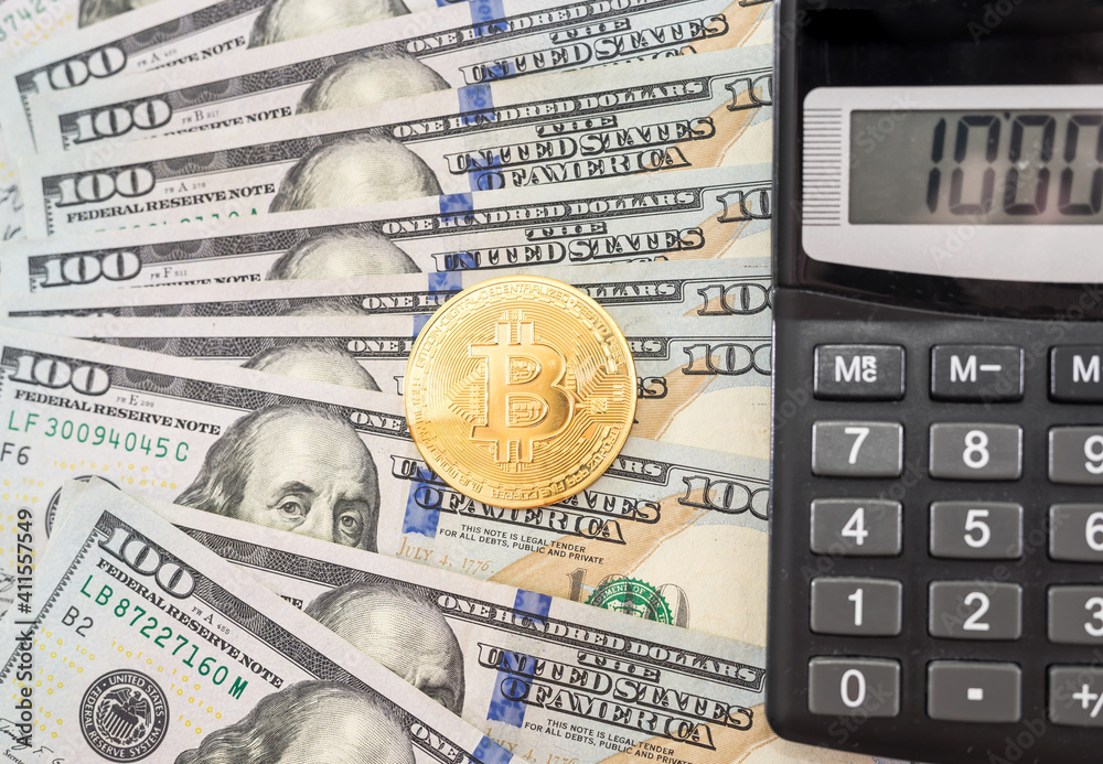 Fototapeta premium bitcoin and calculator on the background of dollars. Gold coin Bitcoin.