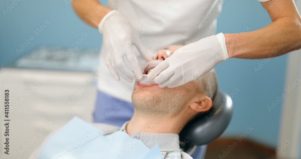 Young male patient with dental braces during a regular orthodontic visit. Dentist adjusting orthodontic brackets. 4k video screenshot, please use in small size Young male patient with dental braces during a regular orthodontic visit. Dentist adjusting orthodontic brackets. 4k video screenshot, please use in small size