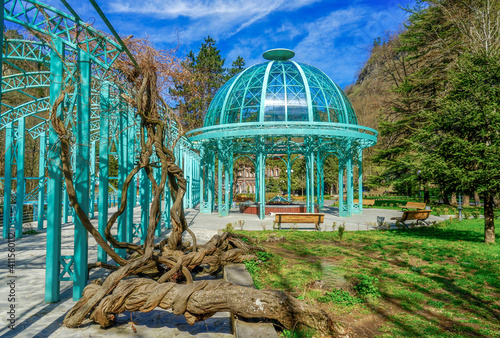 In Georgia the  Spa resort City of Borjomi. In the beautiful public park an iron turquoise pavillon. Surrounded by old trees and old wisteria plants. photo