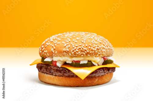 Fotografie Delicious Cheese Beef Burger consists of Bun Bread, Patty, Pickle, Onion, Mayonaisse, Ketchup and Cheddar Cheese in a yellow background, with interactive 3D text for Modern Fast Food Restaurant menu