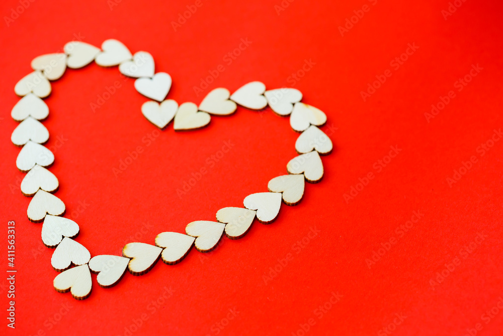 Heart lined with wooden hearts on a bright red background. Place for an inscription, romantic picture for Valentine's Day Heart lined with wooden hearts on a bright red background. Place for an inscription, romantic picture for Valentine's Day
