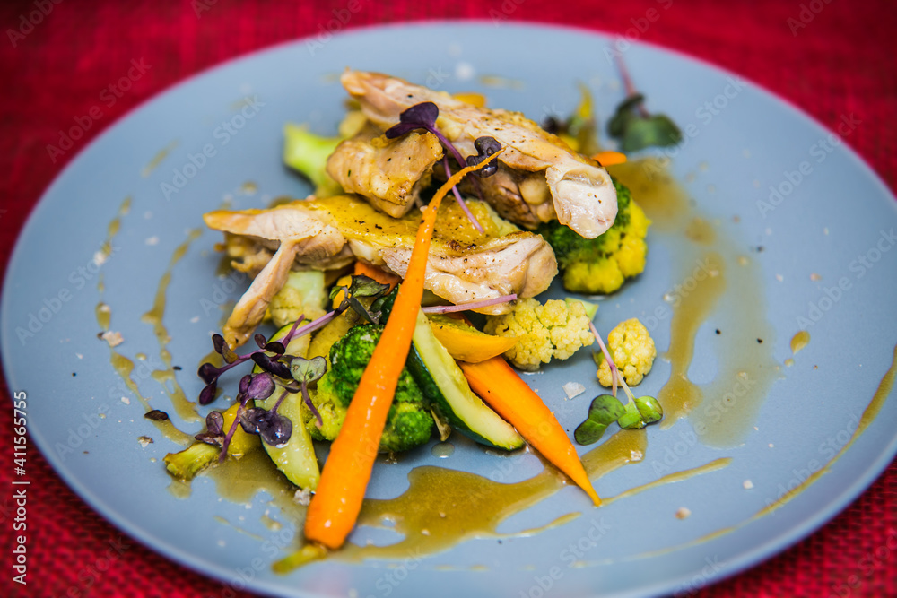 Chicken thigh on roasted vegetables on plate. The food in the restaurant. Food styling and restaurant meal serving. Chicken thigh on roasted vegetables on plate. The food in the restaurant. Food styling and restaurant meal serving.