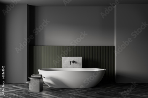 Grey and green bathroom with white bathtub  parquet floor and grey wall