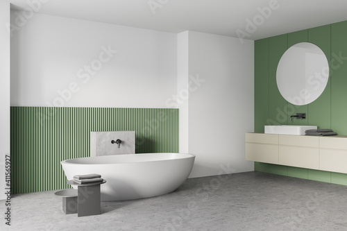 White and green bathroom with white bathtub  mirrors and marble floor