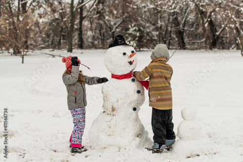 Do you want to build a snowman? Kids playing in snow and building a snowman