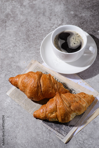 croissants on a gray background and a cup of coffee