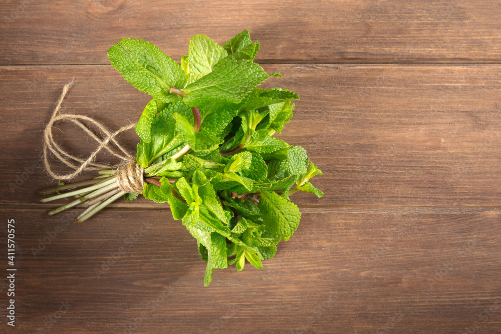 Fresh green mint leaves close-up on a wooden dark background. Mentha piperita plant. Fresh green mint leaves close-up on a wooden dark background. Mentha piperita plant.