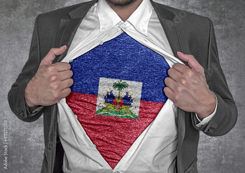 Business man show t-shirt flag of Haiti rips open his shirt photo