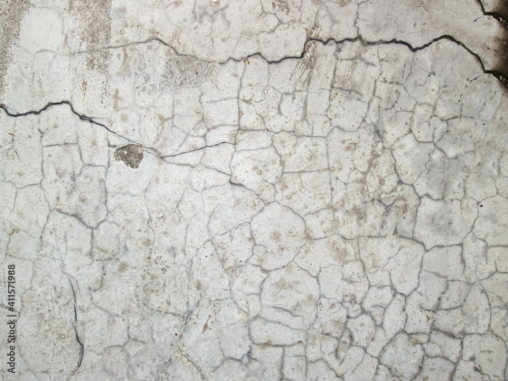 Fototapeta premium Many small cracks on the light stone slab. Broken hard floor surface.