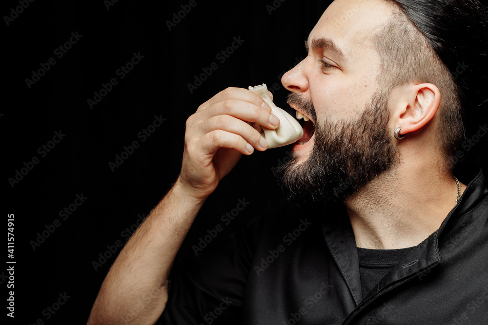 The bearded man is emotionally eating khinkali. The national Georgian dish khinkali. Concept of advertising photo of khinkali The bearded man is emotionally eating khinkali. The national Georgian dish khinkali. Concept of advertising photo of khinkali