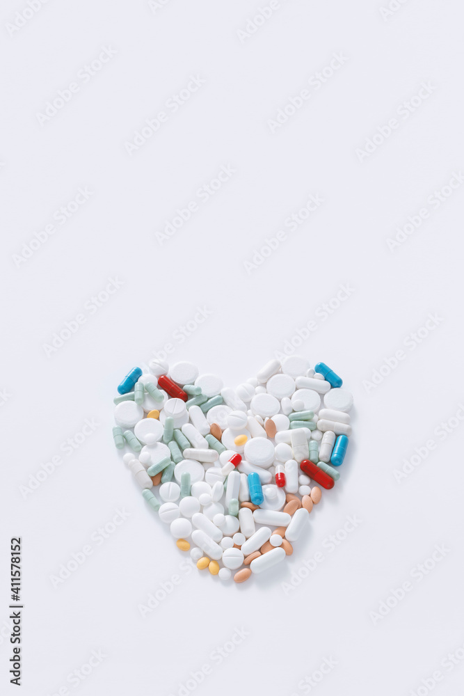 Heart of pills, medicines presented in the form of capsules, dragees and pills from the pharmaceutical industry forming a heart on white background