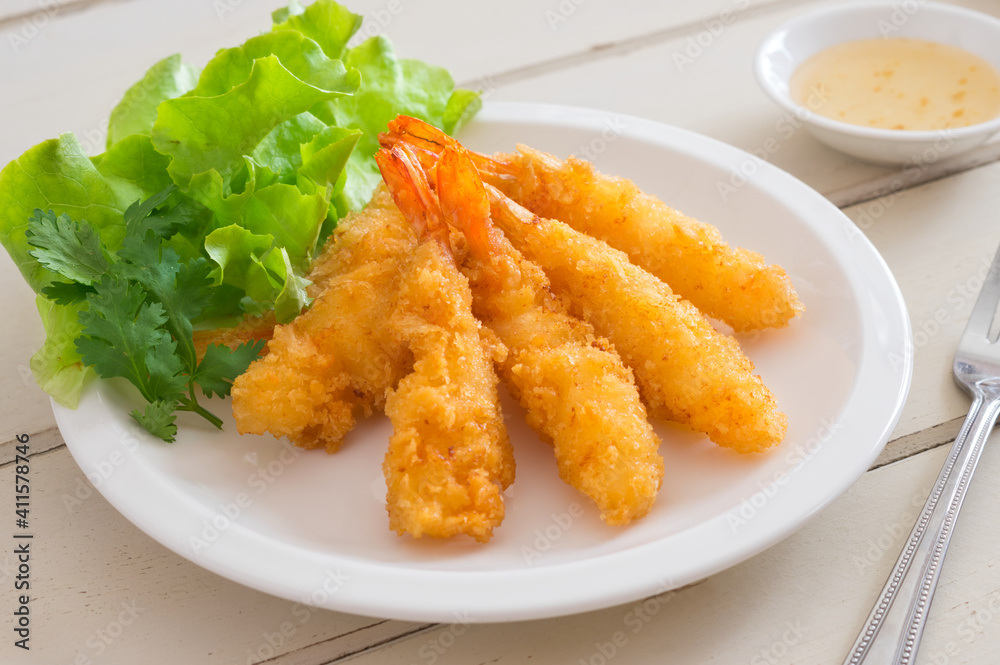 Fried shrimps with green vegetable on plate and dip sauce . Fried shrimps with green vegetable on plate and dip sauce .