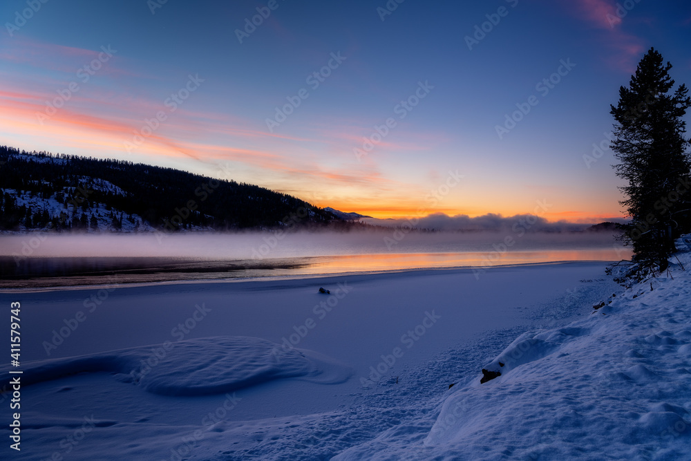 Obraz premium Beautiful sunrise over a winter frozen lake