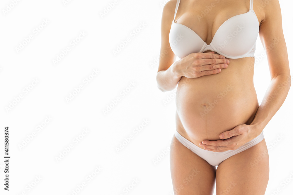 Pregnant woman holds hand on belly. Pregnancy, maternity, preparation and expectation concept. Close-up, copy space, indoors. Beautiful tender mood photo of pregnancy. Pregnant woman holds hand on belly. Pregnancy, maternity, preparation and expectation concept. Close-up, copy space, indoors. Beautiful tender mood photo of pregnancy.