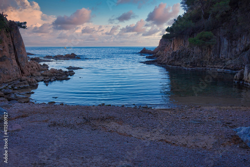 View of one of the small coves of the clustered coast of Aigua Xelida at the beginning of the blue hour where it acquires blue and pink colors. Costa Brava. Begur, Catalonia, Spain photo