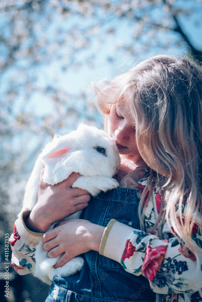 child kissing and whispering to white rabbit, friends forever child kissing and whispering to white rabbit, friends forever