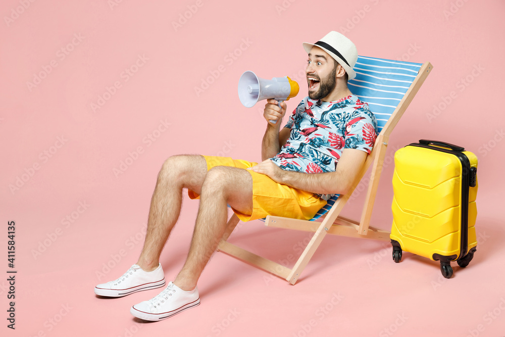 Full length shocked traveler tourist man in summer clothes hat sit on deck chair screaming in megaphone isolated on pink background. Passenger traveling on weekend getaway. Air flight journey concept. - obrazy, fototapety, plakaty 