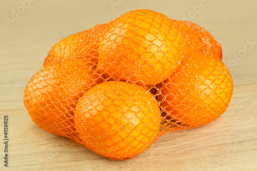 Sieben Orangen im Netz auf Holz
