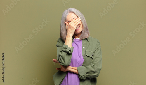 senior woman looking stressed, ashamed or upset, with a headache, covering face with hand
