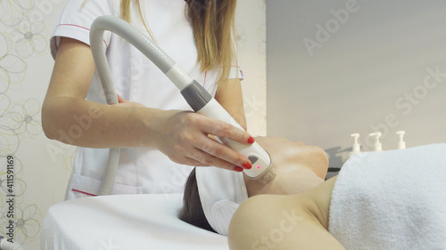 Young woman undergoing procedure of rf lifting in beauty salon, close up