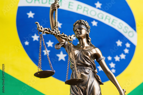 The statue of justice Themis or Justitia, the blindfolded goddess of justice against the flag of Brazil, as a legal concept photo
