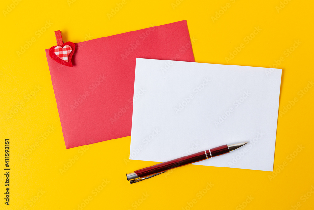 White page with a red envelope on a yellow background. Place for text White page with a red envelope on a yellow background. Place for text