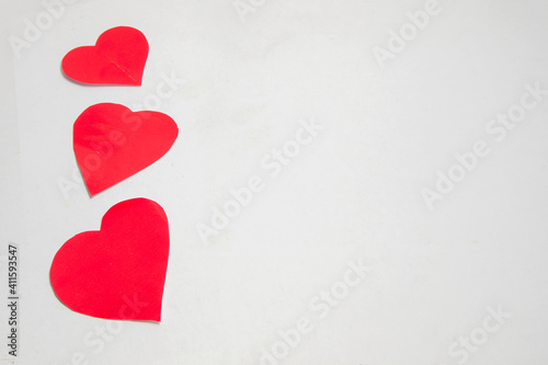 three red paper hearts in vertical isolated on white background