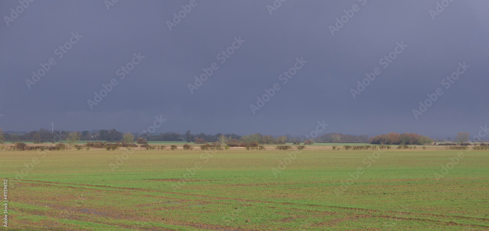 English countryside with deep grey blue sky and green field with copy space English countryside with deep grey blue sky and green field with copy space