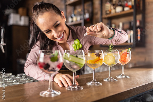 Photos Bartender makes summer refreshing gin tonic cocktails on a bar