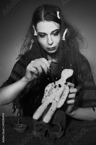 voodoo witch spelling fetish doll practicing magic ritual photo