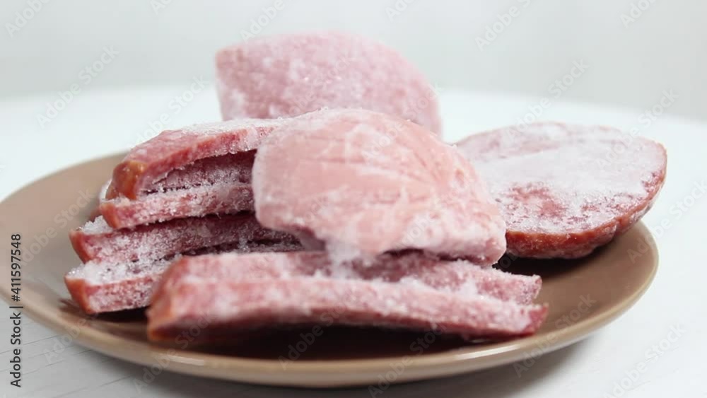 Pieces of different Frozen sausage on a plate. Different food blanks. Close-up, selective shot. Pieces of different Frozen sausage on a plate. Different food blanks. Close-up, selective shot.