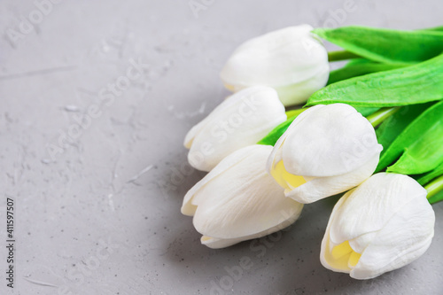 bouquet of white tulips on concrete background or surface  the concept of women s holiday or gift for woman