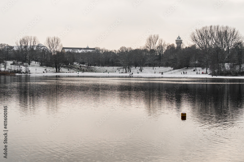 Holiday at lake in winter, snowy shore, symmetrical reflections in water mirror