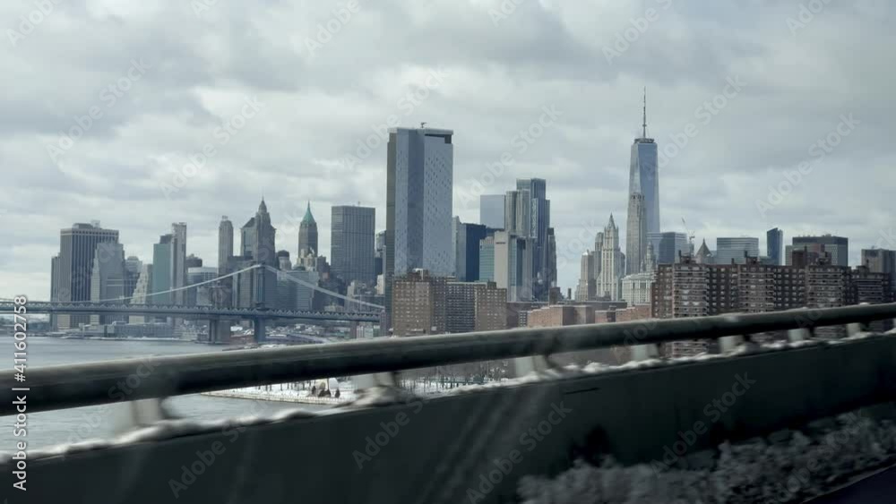 driving view of Freedom Tower in Manhattan skyline from Williamsburg Bridge with snow in winter New York City NYC driving view of Freedom Tower in Manhattan skyline from Williamsburg Bridge with snow in winter New York City NYC