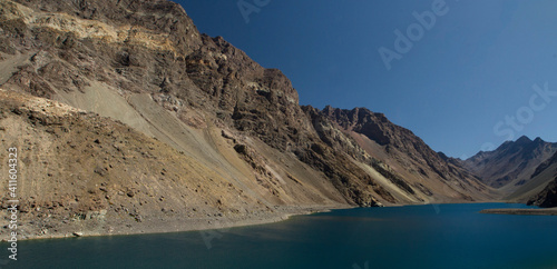 The glacier water lake in the Andes cordillera in a summer sunny day. Panorama view of the turquoise color lake called Inca Lagoon high in the Andes mountain range in Portillo, Chile. 