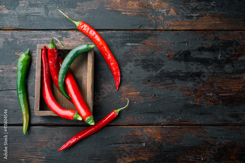 Red and green chili pepper, in wooden box, on dark wooden background, top view flat lay , with copyspace and space for text