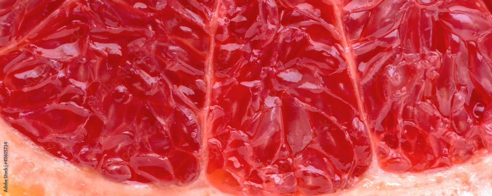 Piece of fresh grapefruit with juicy red pulp cut in half