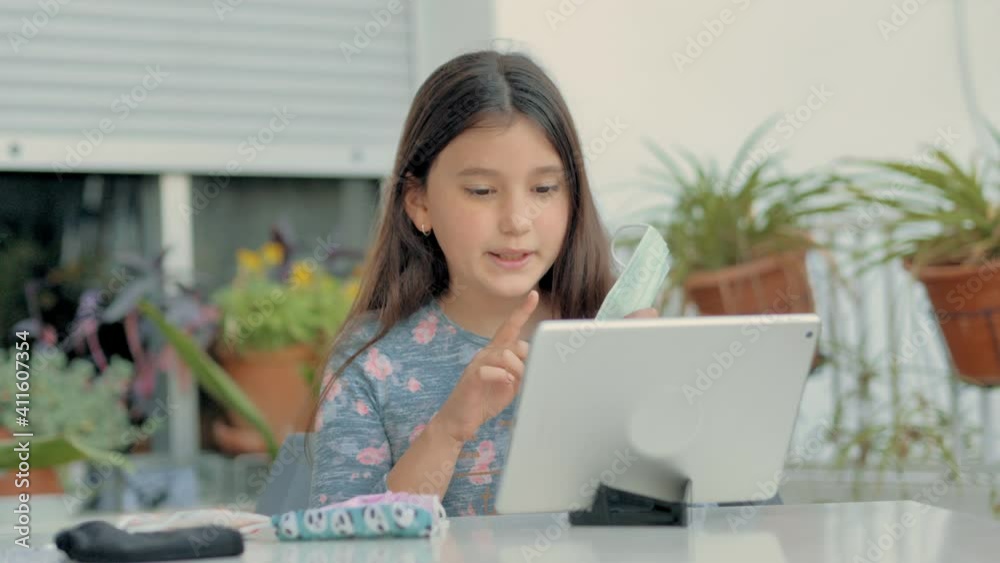 Niña enseñando a su familia por internet varios modelos y colores de máscaras  covid-19