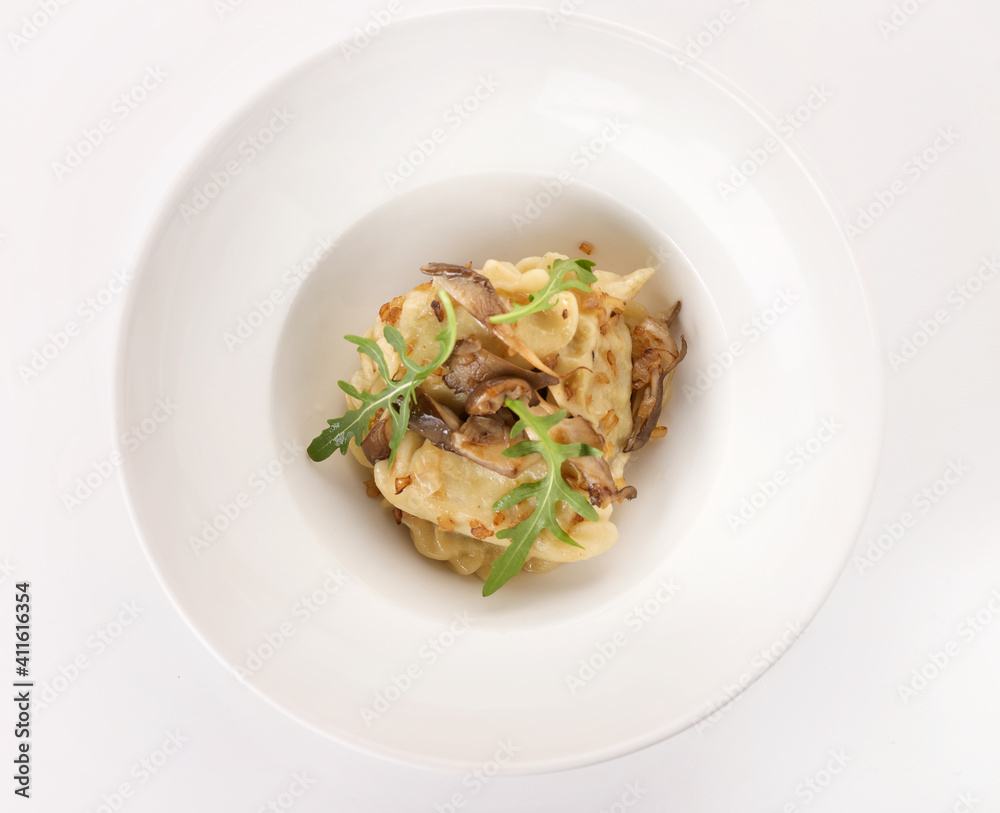 dumplings with mushrooms and hand on a white plate 