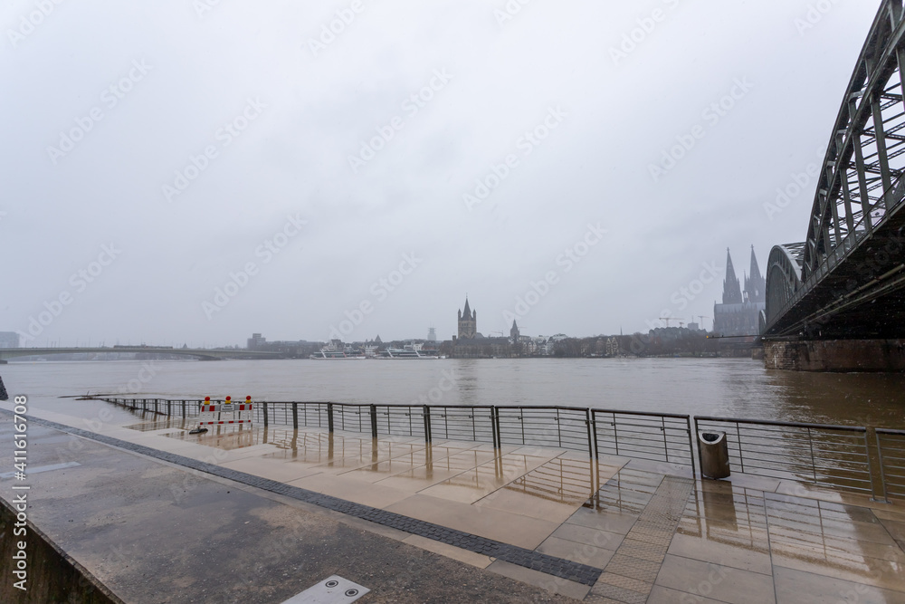 panorama of Cologne with cathedral and hohenzollern bridge at snowy weather. rhine river with high water