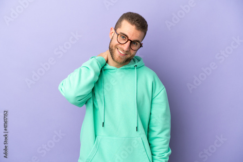 Young handsome caucasian man isolated on purple background laughing © luismolinero