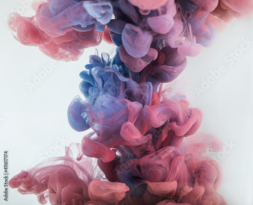 Purple splash of paint ink in water, liquid color backdrop