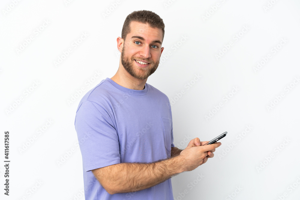 Young handsome caucasian man isolated on white background sending a message or email with the mobile Young handsome caucasian man isolated on white background sending a message or email with the mobile