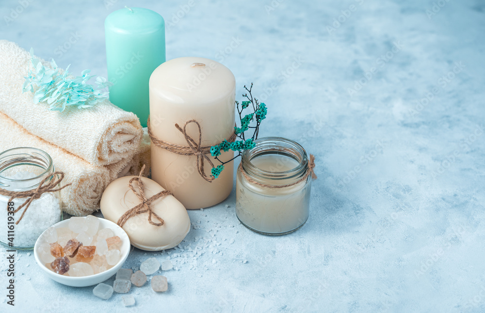 Spa composition with candles and cleansers on a soft blue background. Side view, horizontal. The concept of skin care. Spa composition with candles and cleansers on a soft blue background. Side view, horizontal. The concept of skin care.