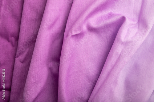 Fragment of cotton purple tissue. Top view, natural textile background.