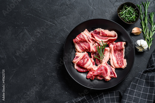 Strips of marbled beef, quick steak. Black background. Top view. Copy space