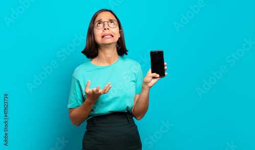 Fotografie young hispanic woman looking desperate and frustrated, stressed, unhappy and ann
