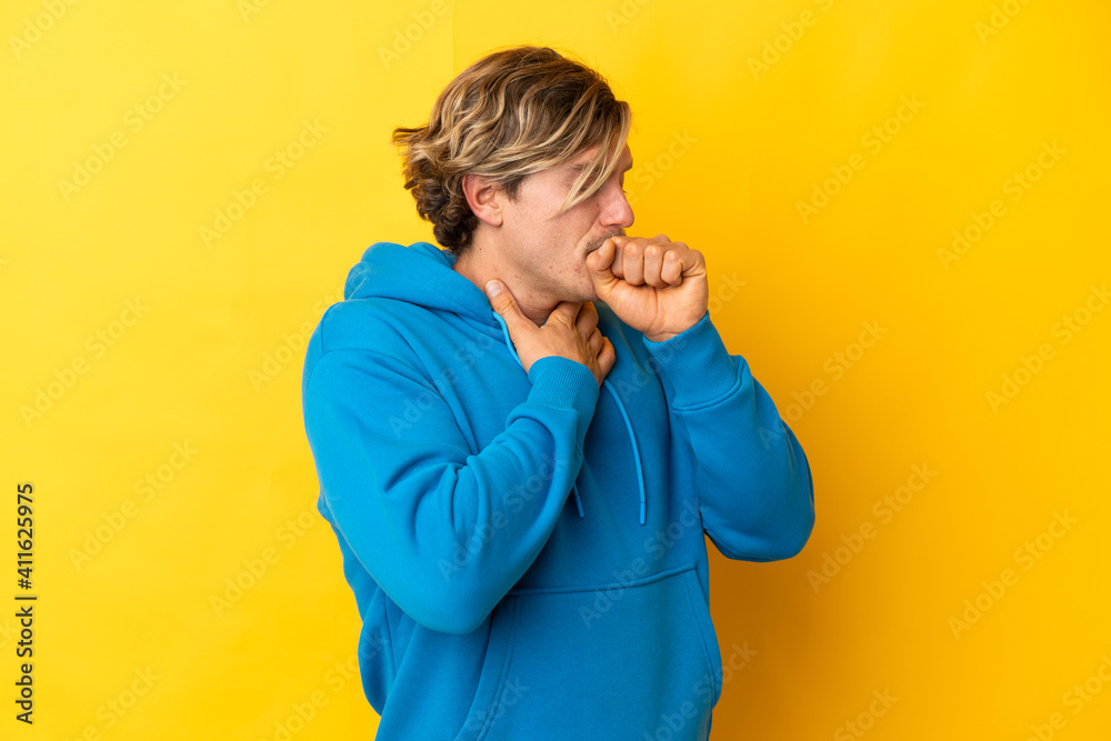 Handsome blonde man isolated on yellow background coughing a lot Handsome blonde man isolated on yellow background coughing a lot