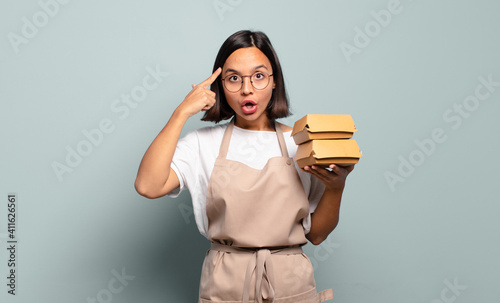 Принти на полотні young hispanic woman looking surprised, open-mouthed, shocked, realizing a new t